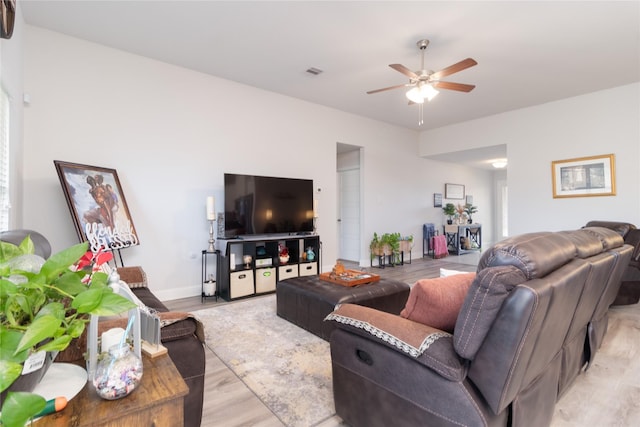 living room with ceiling fan and light hardwood / wood-style flooring