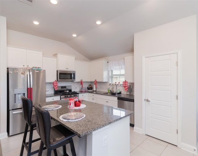 kitchen featuring dark stone counters, white cabinets, sink, a kitchen island, and stainless steel appliances