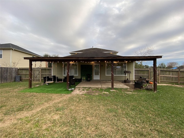 rear view of property with a patio and a lawn