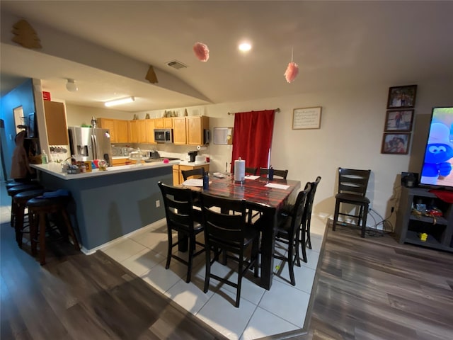 dining space featuring light hardwood / wood-style flooring and vaulted ceiling