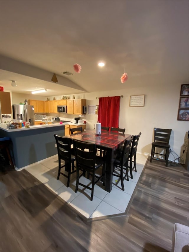 dining room featuring light hardwood / wood-style floors and lofted ceiling