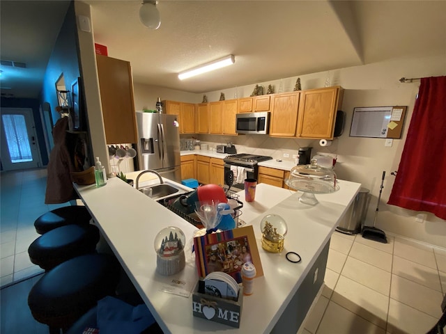 kitchen with decorative backsplash, light tile patterned floors, sink, and appliances with stainless steel finishes