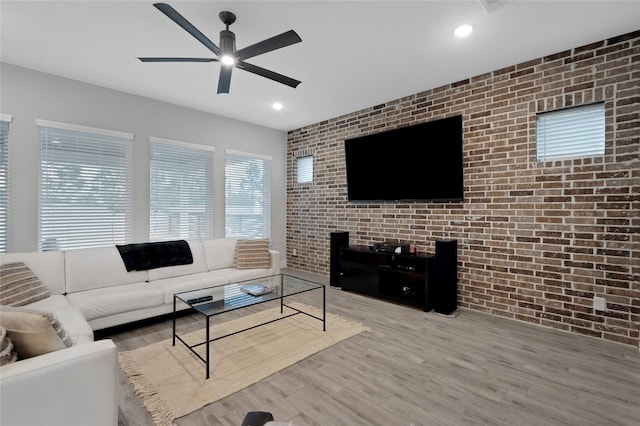 living area with recessed lighting, ceiling fan, brick wall, and wood finished floors