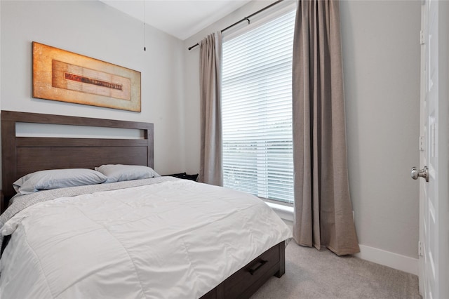 bedroom with light carpet and baseboards