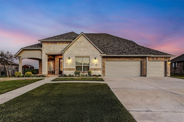 view of front of home featuring a garage and a lawn