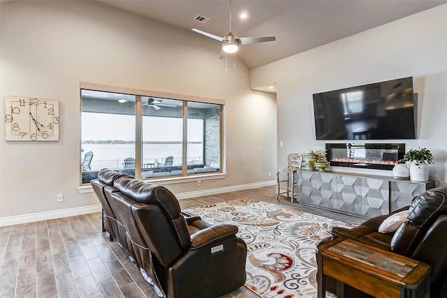 living room with lofted ceiling, hardwood / wood-style floors, and ceiling fan