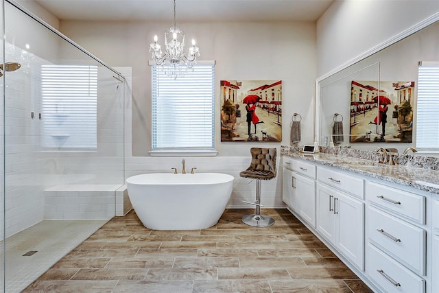 bathroom with tile walls, vanity, a healthy amount of sunlight, and separate shower and tub