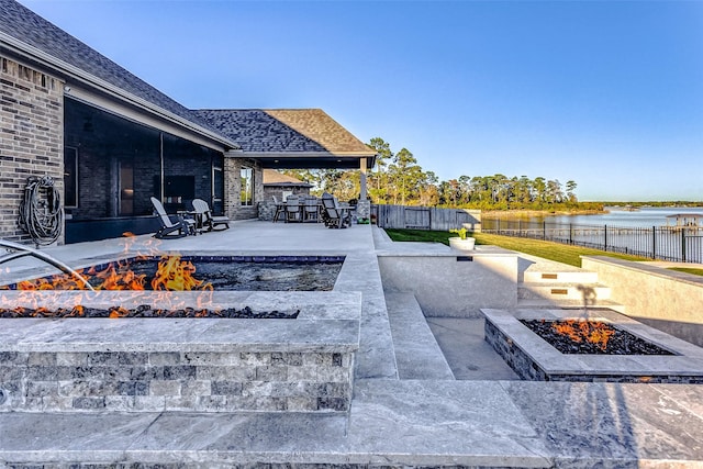 view of patio featuring a bar, a fire pit, and a water view