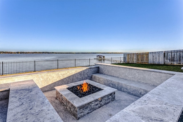 view of patio with a water view and a fire pit