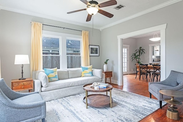 living room with ceiling fan, hardwood / wood-style floors, and crown molding