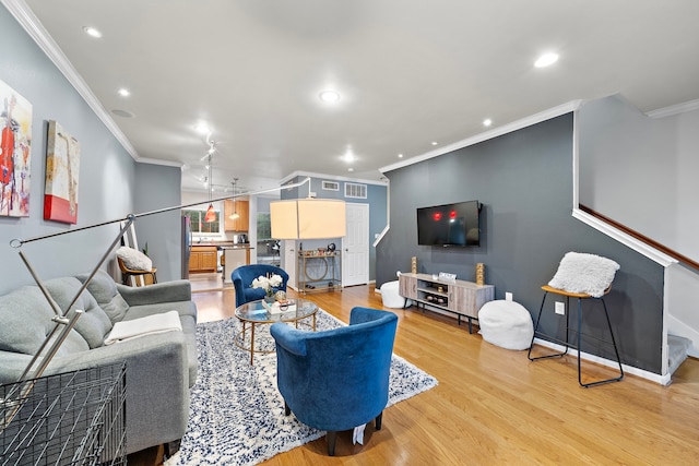 living room with light hardwood / wood-style floors and crown molding