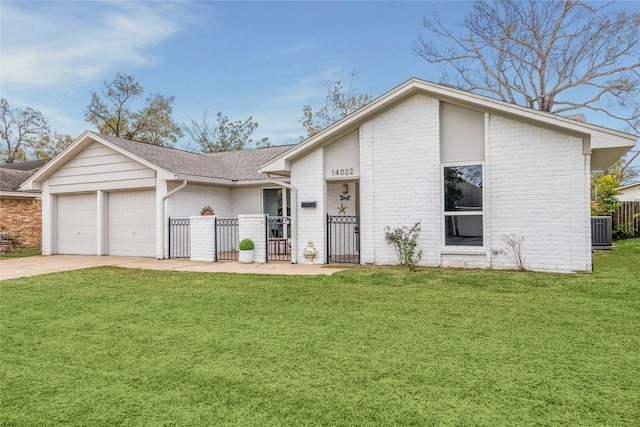 view of front of property featuring central air condition unit, a front yard, and a garage