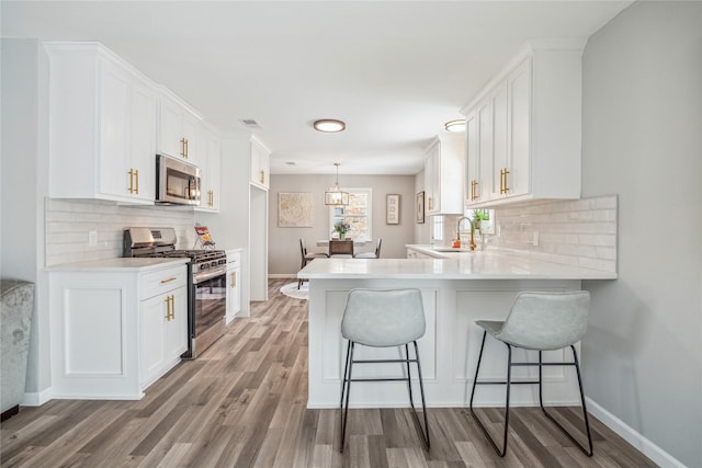 kitchen featuring stainless steel appliances, white cabinetry, and decorative backsplash