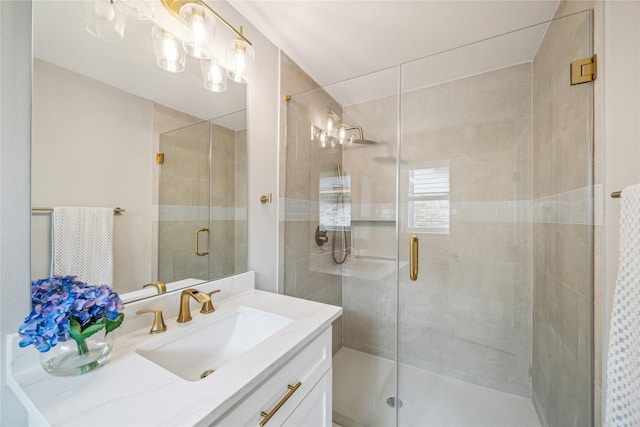 bathroom featuring a shower with door and vanity