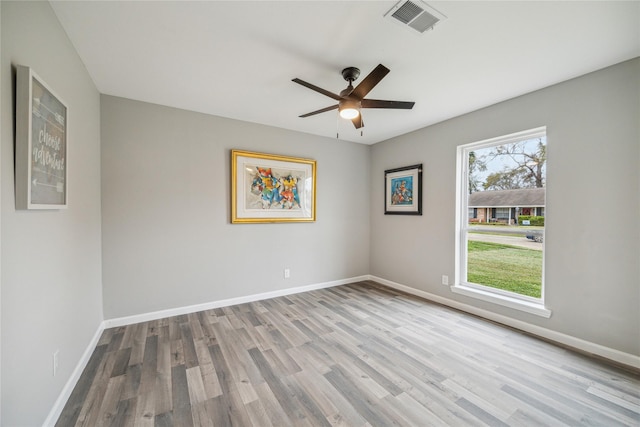 empty room with ceiling fan and light hardwood / wood-style flooring