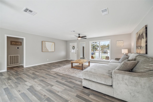 living room featuring wood-type flooring and ceiling fan