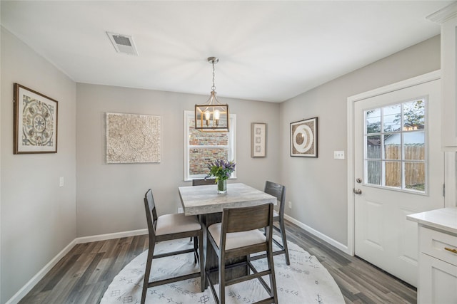 dining area with a chandelier and dark hardwood / wood-style floors