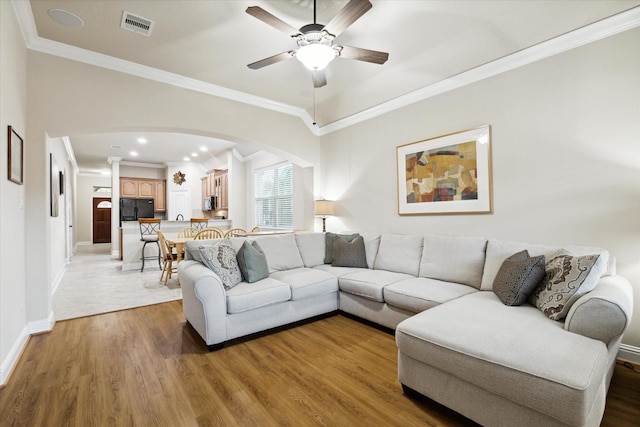 living room featuring ceiling fan, ornamental molding, and hardwood / wood-style flooring