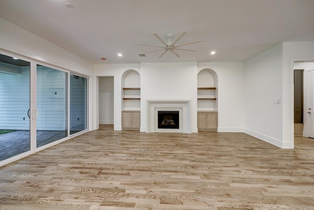 unfurnished living room featuring ceiling fan, built in features, and light hardwood / wood-style flooring