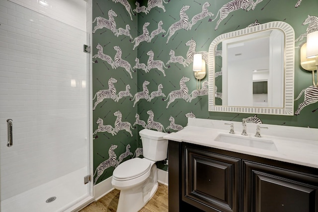 bathroom with hardwood / wood-style flooring, toilet, an enclosed shower, and vanity