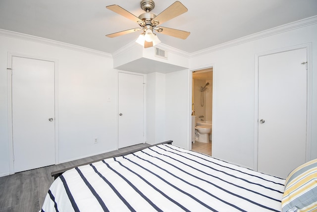 unfurnished bedroom featuring dark wood-type flooring, crown molding, ensuite bath, ceiling fan, and a closet