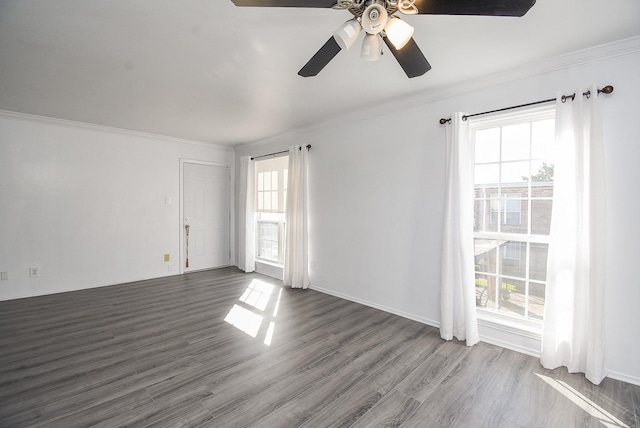 spare room featuring plenty of natural light, ceiling fan, and dark hardwood / wood-style flooring