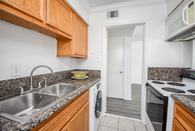 kitchen featuring white appliances, crown molding, sink, light tile patterned floors, and washer / dryer