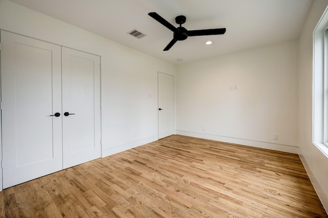 unfurnished bedroom with a closet, light hardwood / wood-style floors, and ceiling fan