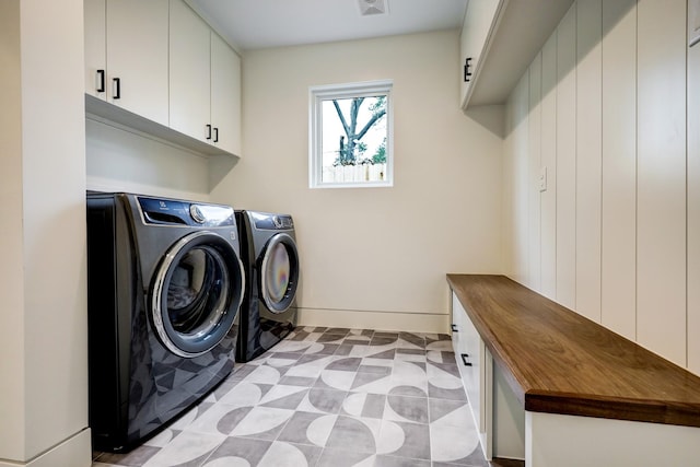 laundry area featuring cabinets and washing machine and clothes dryer