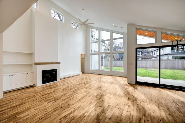 unfurnished living room with light hardwood / wood-style flooring, plenty of natural light, and ceiling fan