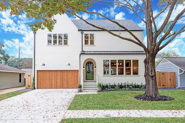 view of property with a garage and a front lawn