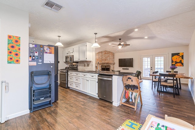 kitchen featuring white cabinetry, hanging light fixtures, appliances with stainless steel finishes, and tasteful backsplash