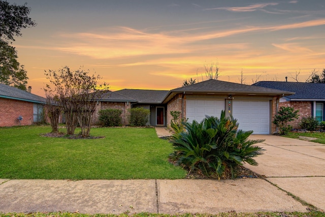 ranch-style house with a garage and a yard