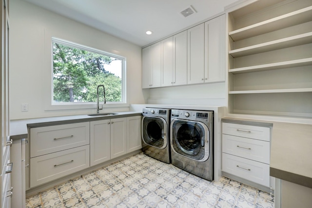 laundry room featuring cabinets, sink, and washer and dryer