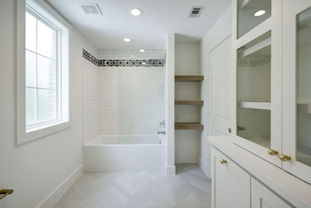 bathroom featuring tiled shower / bath combo and a wealth of natural light