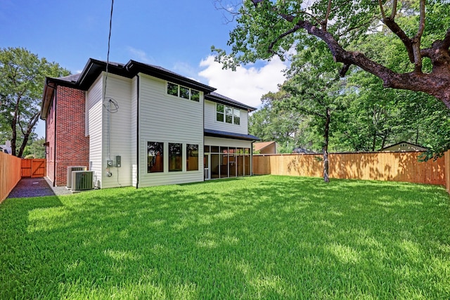 back of house with a lawn and central AC unit