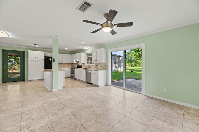 kitchen featuring backsplash, white cabinets, crown molding, ceiling fan, and appliances with stainless steel finishes