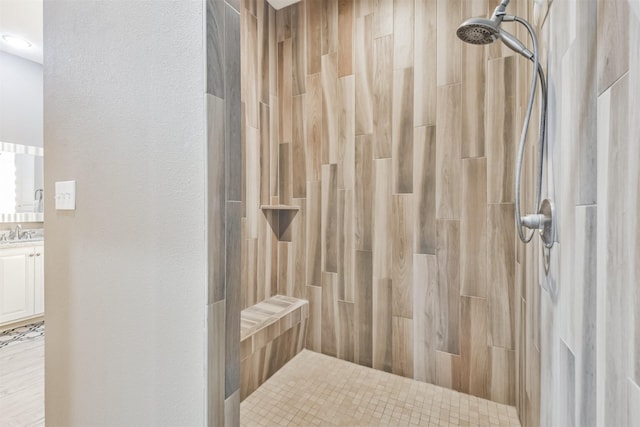 bathroom with a tile shower and sink