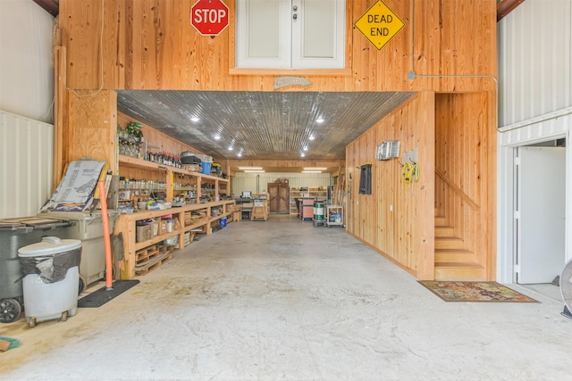 garage with a workshop area and wooden walls