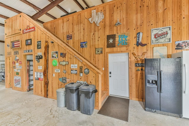 interior space with concrete floors and wooden walls