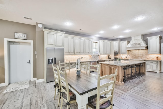 dining room featuring sink and light hardwood / wood-style floors