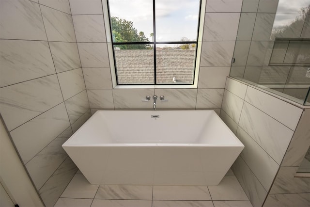 bathroom featuring a washtub and tile patterned flooring