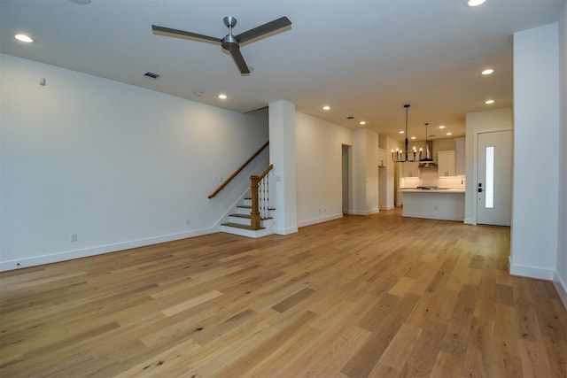 unfurnished living room with ceiling fan and light hardwood / wood-style flooring