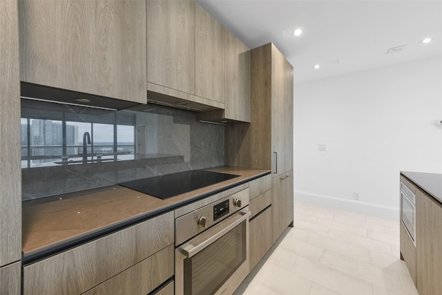 kitchen with black electric stovetop, oven, light brown cabinetry, tasteful backsplash, and extractor fan