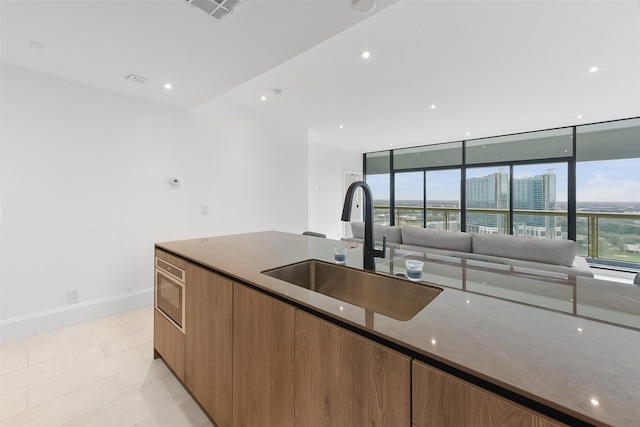 kitchen featuring light tile patterned flooring, sink, and stone counters