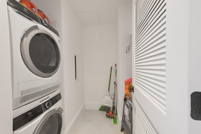 clothes washing area featuring stacked washer and clothes dryer