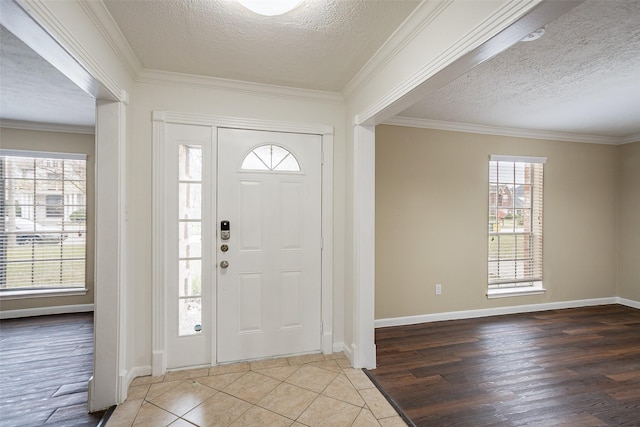 entrance foyer with a textured ceiling, ornamental molding, and hardwood / wood-style floors