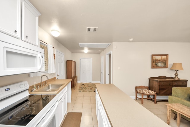 kitchen featuring white cabinetry, sink, white appliances, and light tile patterned flooring