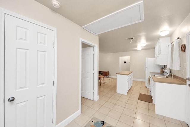 kitchen featuring white cabinetry, light tile patterned floors, and sink