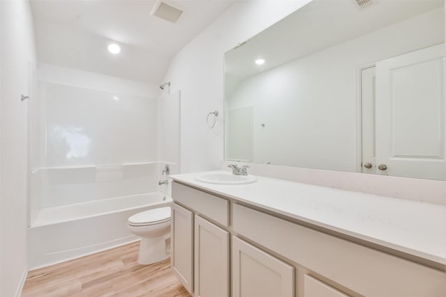 full bathroom with  shower combination, toilet, vanity, and hardwood / wood-style flooring